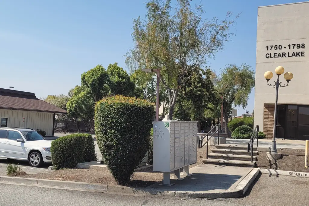 The walkway and steps from the parking lot to the building, past the 1750–1798 Clear Lake sign and lamp posts
